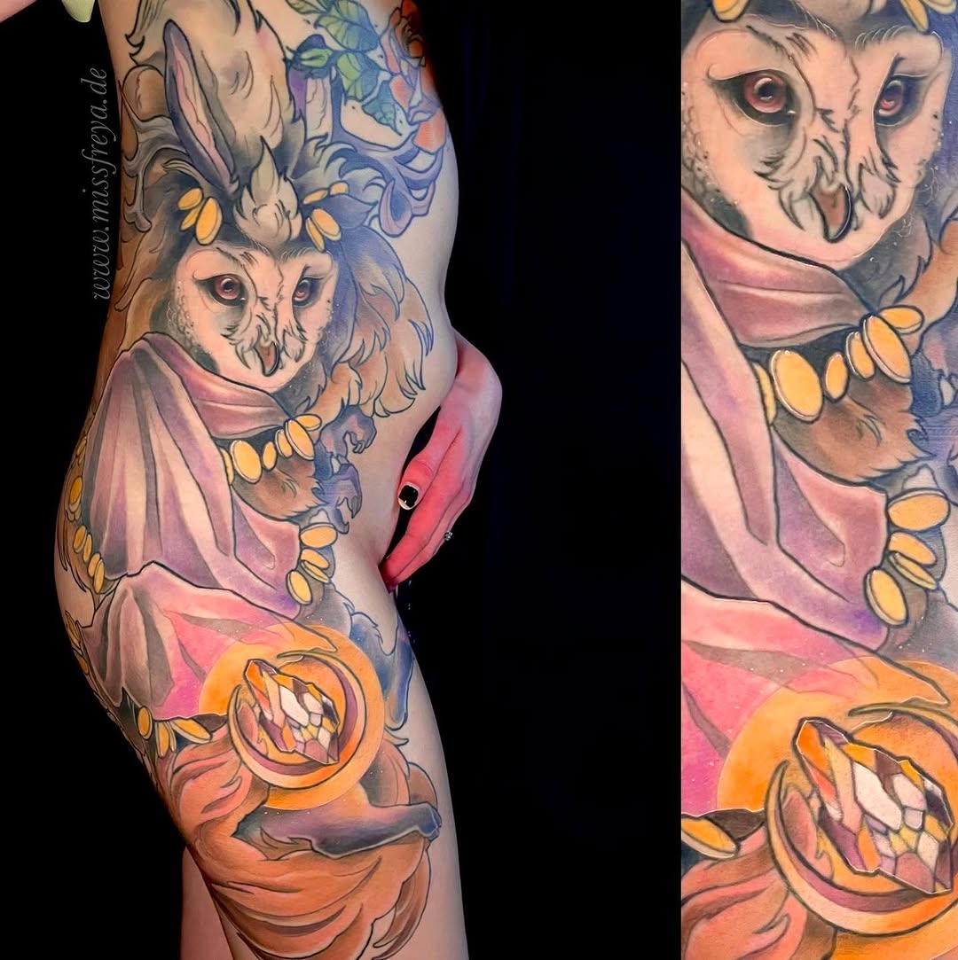 Colorful leg tattoo featuring two owls with detailed facial features wearing pink robes, surrounded by yellow flowers and orange circular elements.