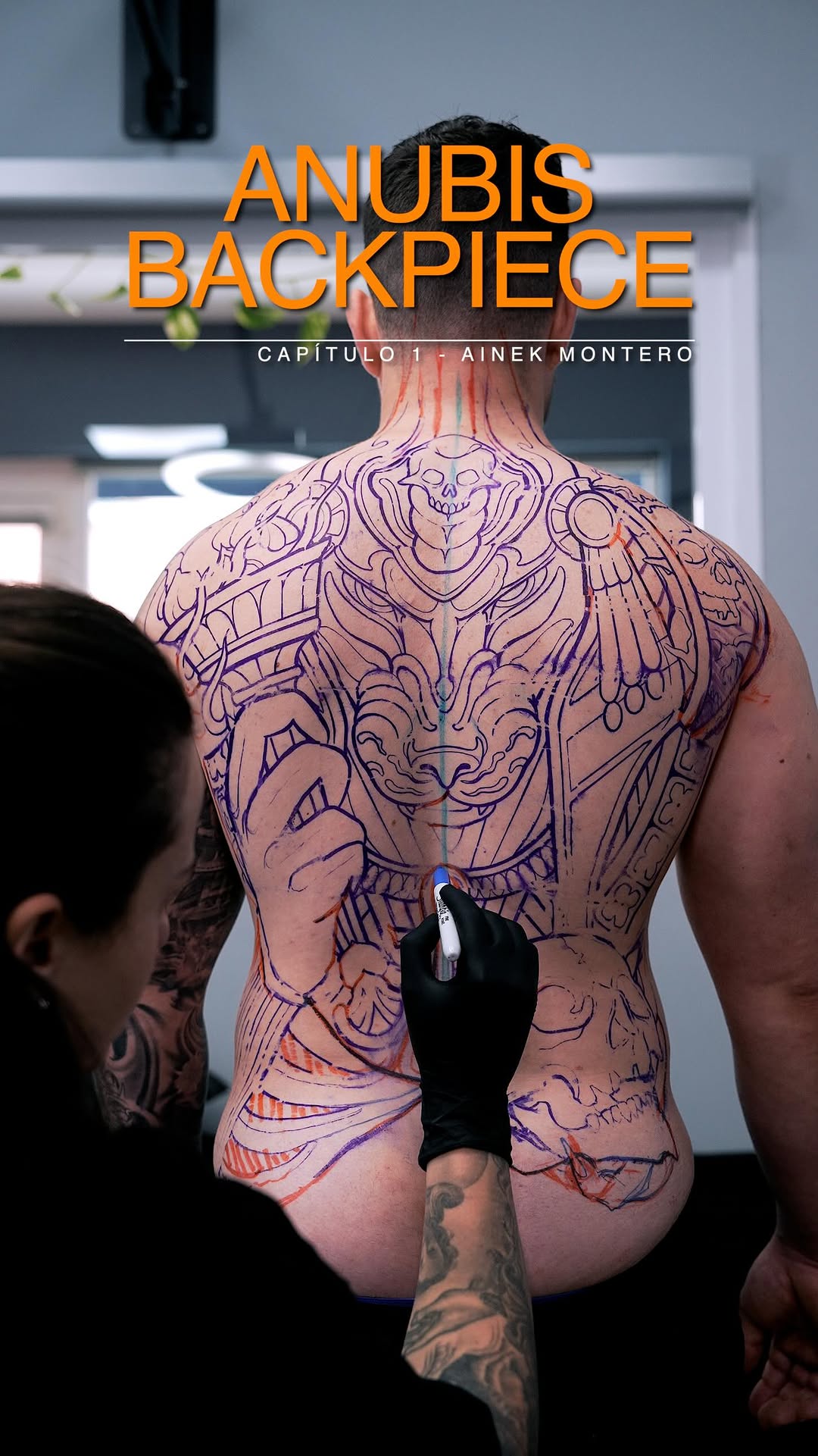 Elaborate back tattoo featuring mythological and animal imagery in purple and orange ink on a male client's torso, with an artist's hand holding a marker during design planning.