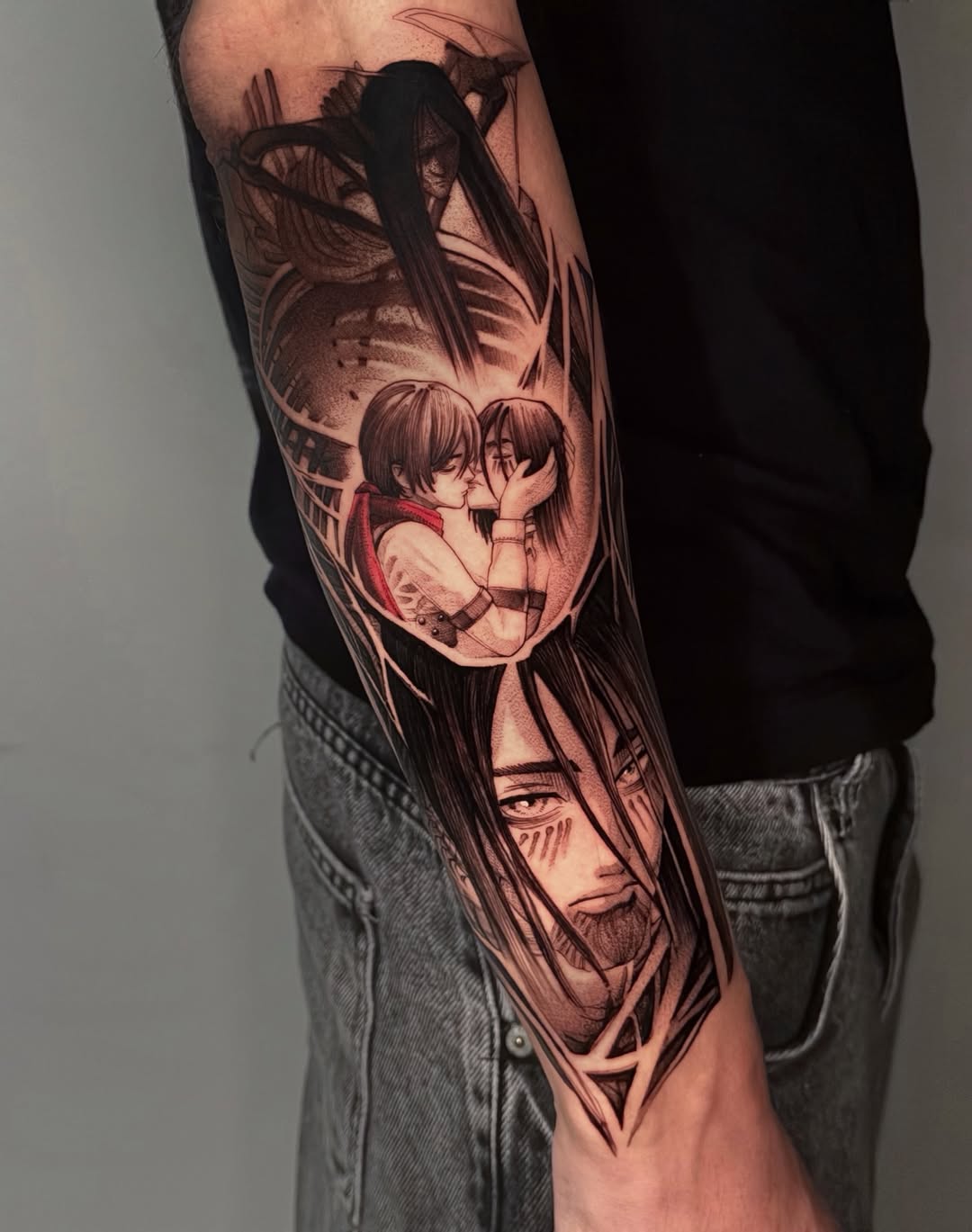 Full-sleeve arm tattoo featuring anime-style characters with detailed facial expressions in sepia and red tones on a person wearing gray jeans and black shirt.