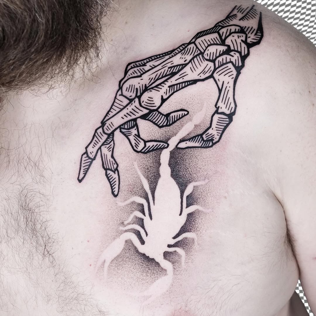 Skeletal hand and arm anatomy tattoo on chest with line work and shading detail in black ink.