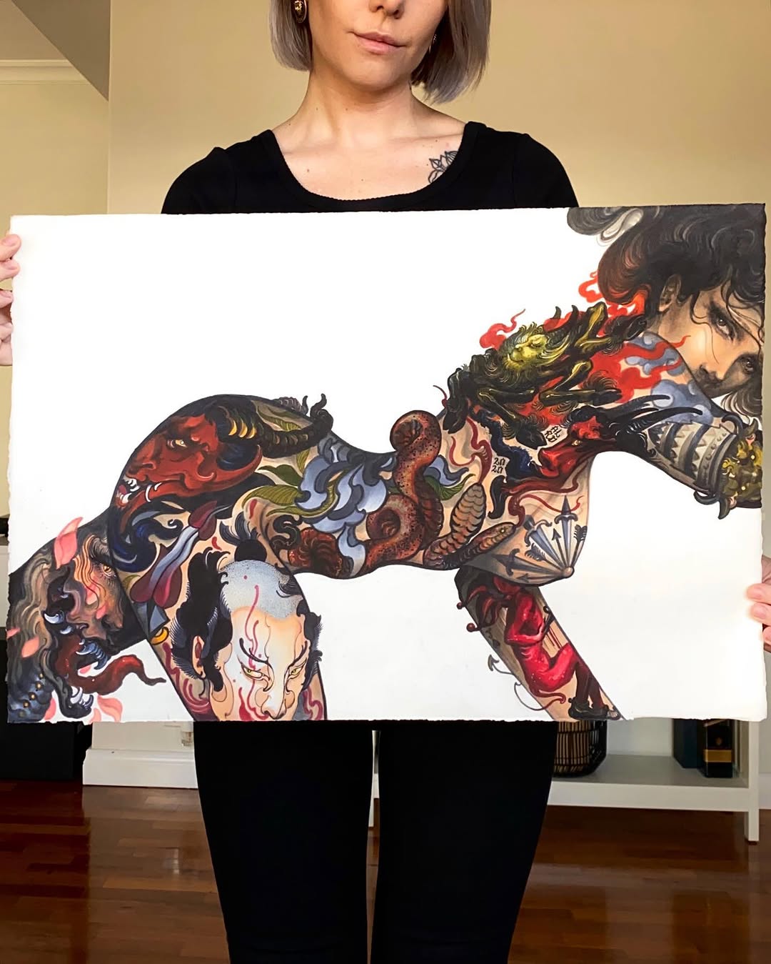 Colorful dragon tattoo covering the upper back and shoulders with red, gold, and blue detailing, displayed on white paper.