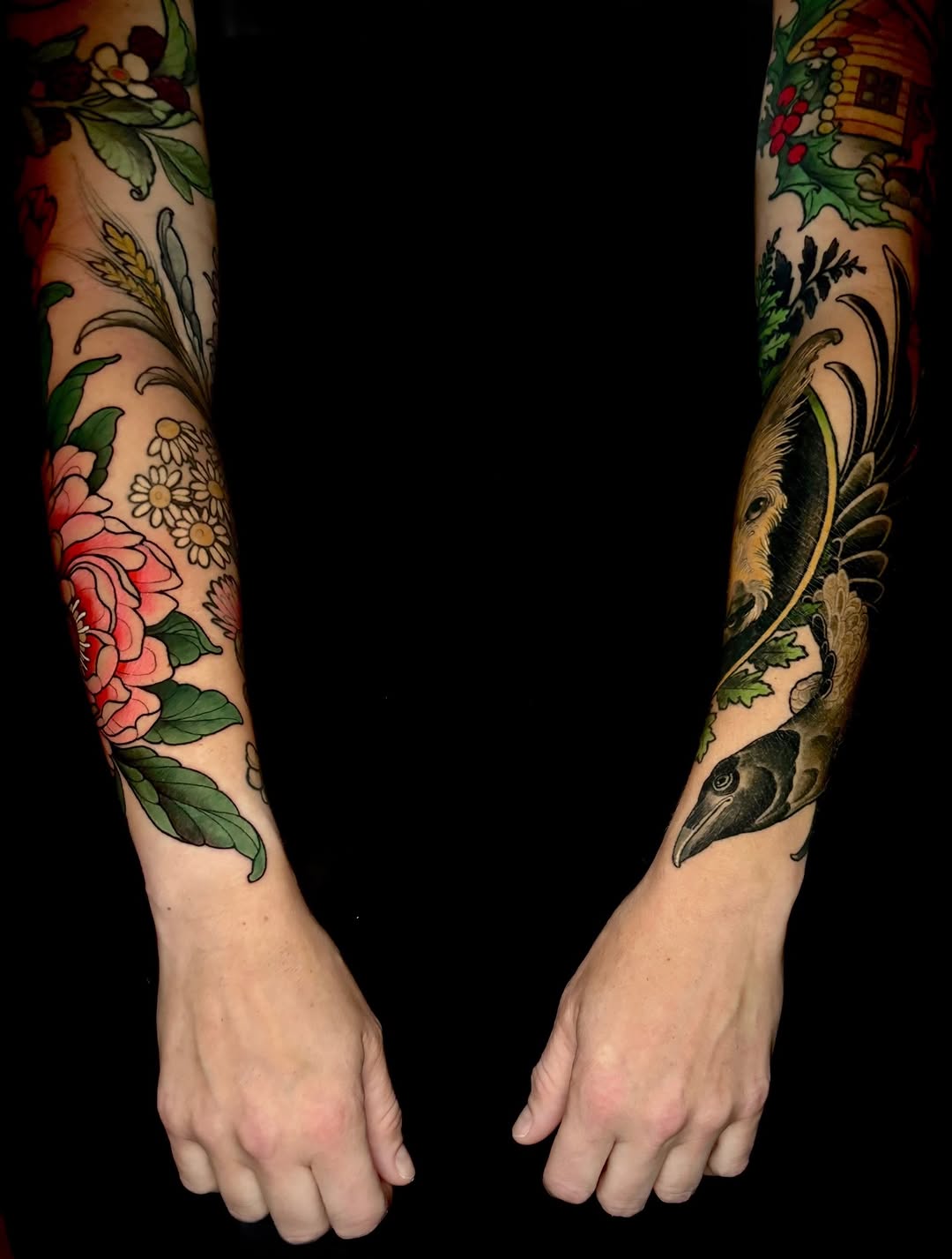 Two full-length sleeves featuring botanical elements including pink roses, daisies, birds, and decorative foliage in red, green, gold, and black colors on pale skin.