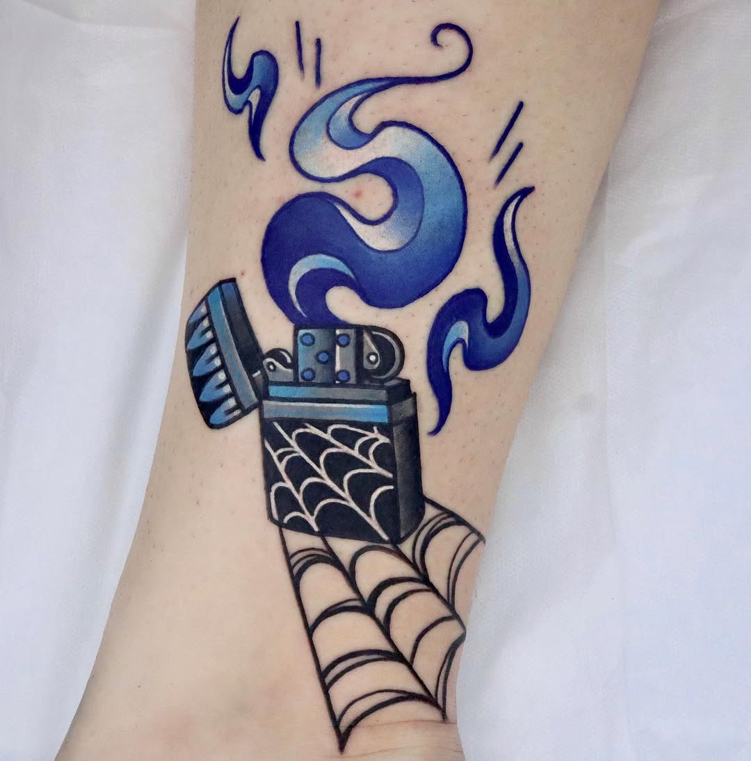 Colorful tattoo on an arm featuring a lighter with blue flame and spider web design, surrounded by decorative swirls.