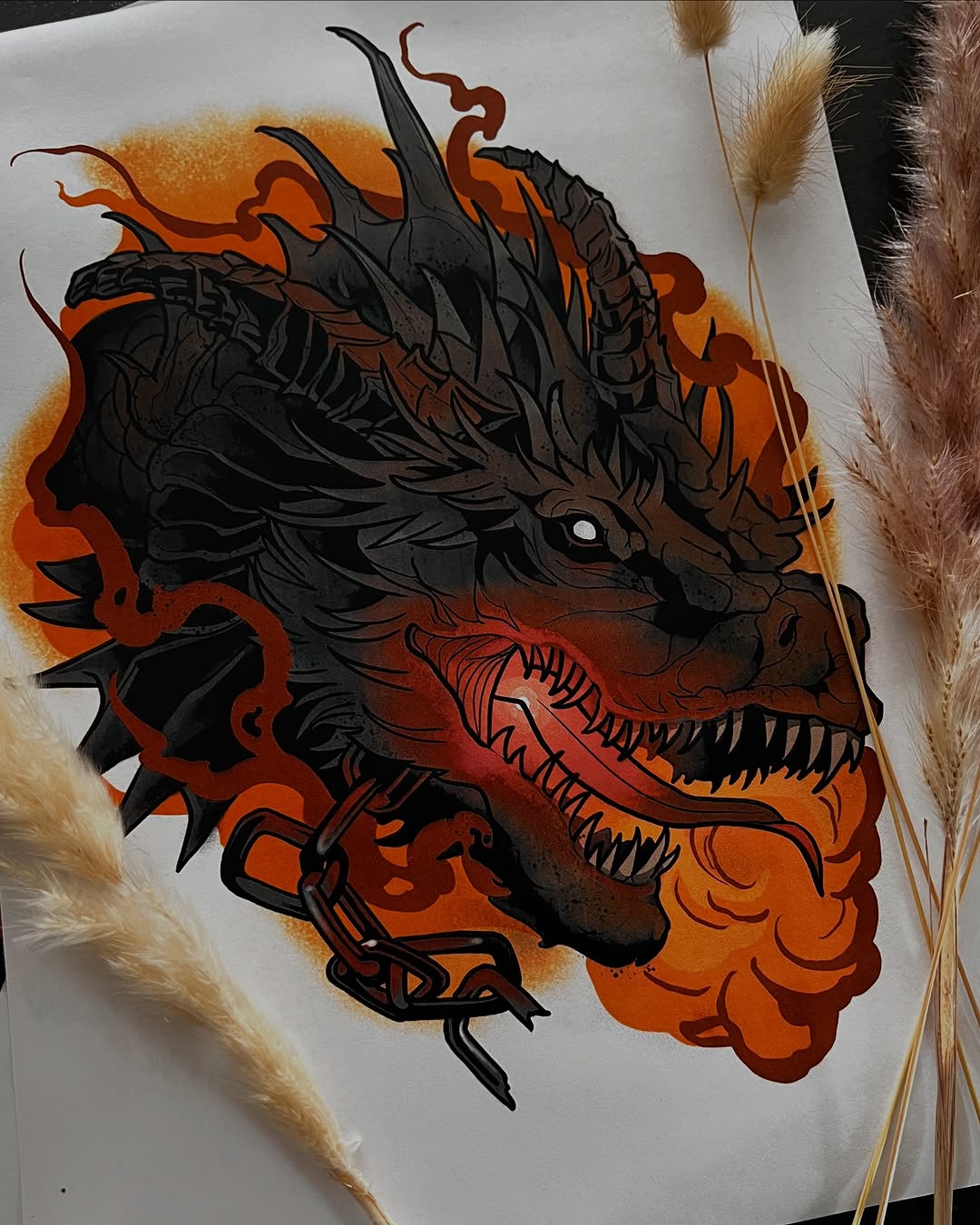 Dragon head in profile with black outlines and orange-red gradient shading, featuring horns, sharp teeth, and flowing details on white paper.