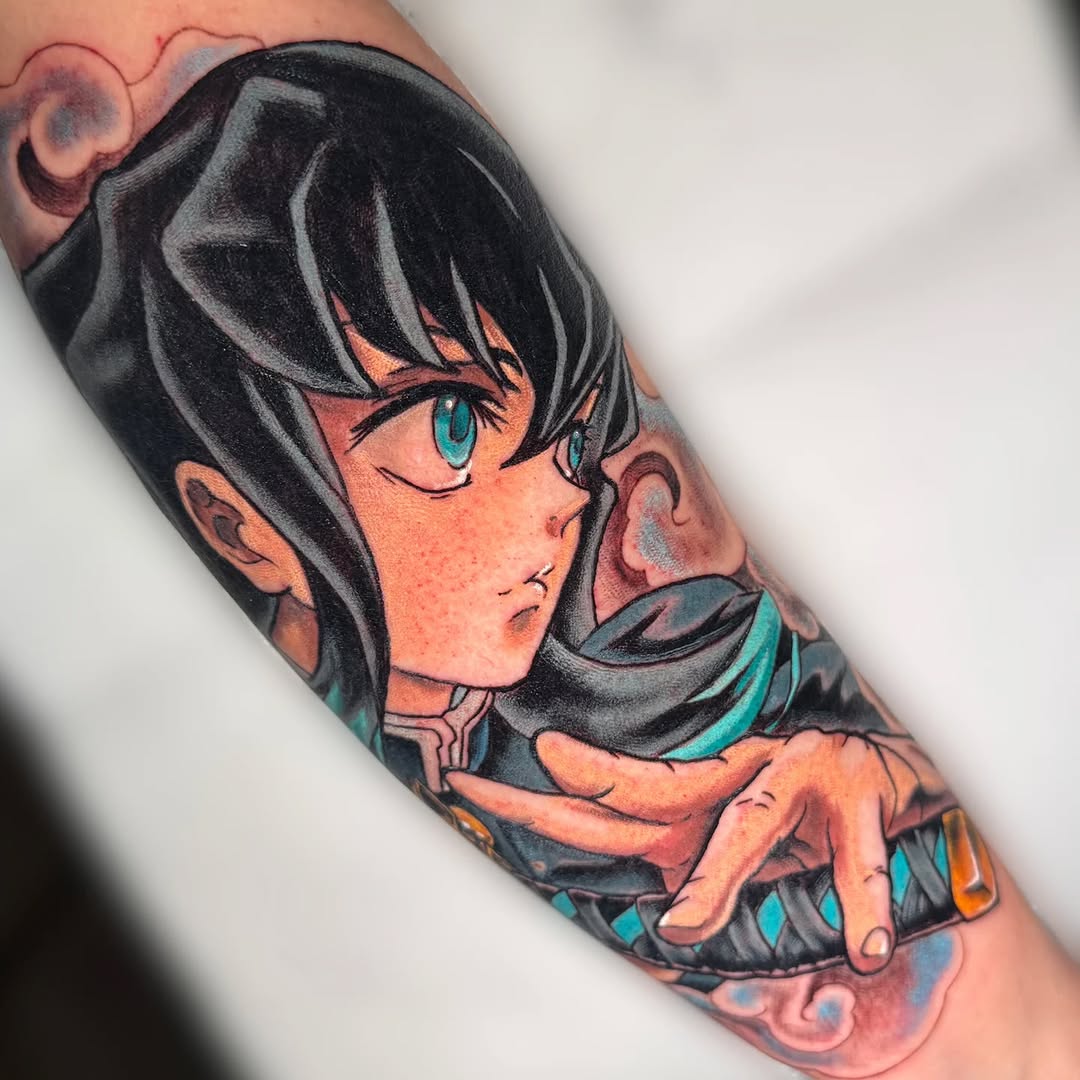 Colorful tattoo on a forearm featuring a young anime character with black hair and turquoise eyes, wearing dark clothing with teal and orange accents.