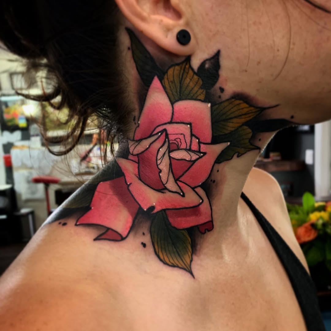 Red rose with black outline and green-brown leaves on a person's neck and shoulder area.