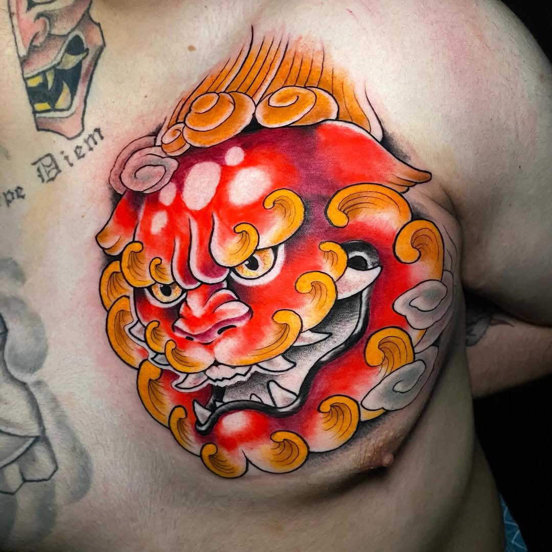 Red demon or oni mask face with golden curled horns and decorative scrollwork on chest, featuring white highlight details and gradient shading.