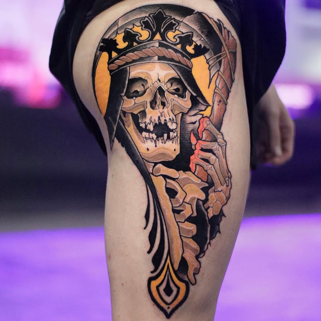 Skull wearing an ornate crown with a bearded face and skeletal jaw, rendered in black, orange, and red on the thigh.