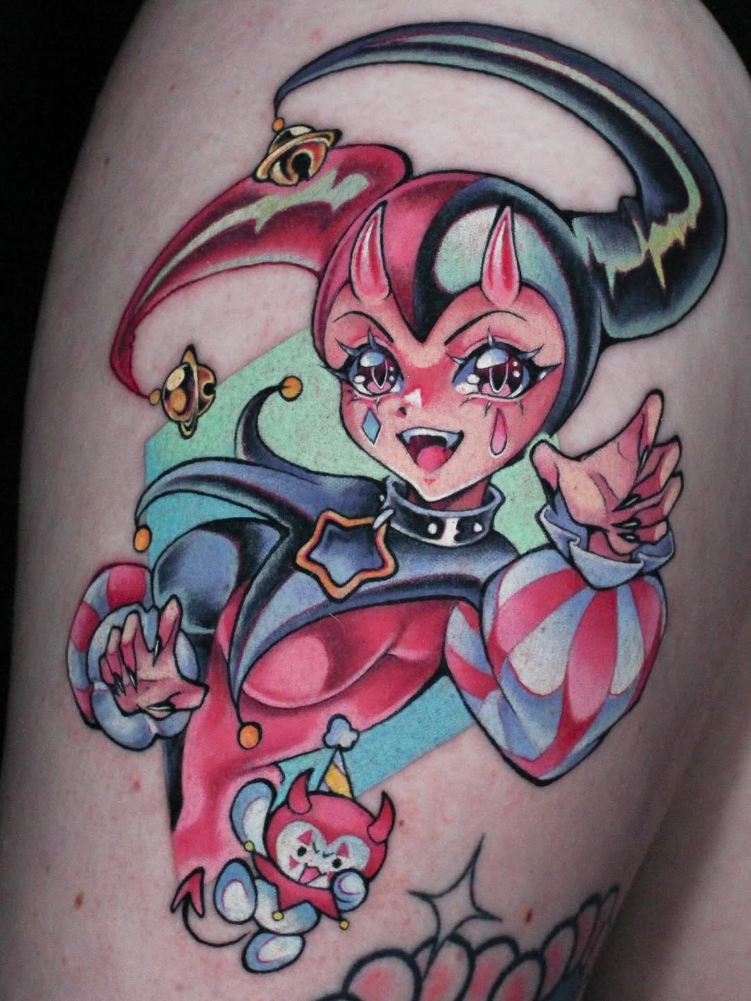 Colorful character tattoo on upper arm featuring a pink-skinned figure with pointed ears, black hair with headband, red and blue outfit, and small companion creature below.