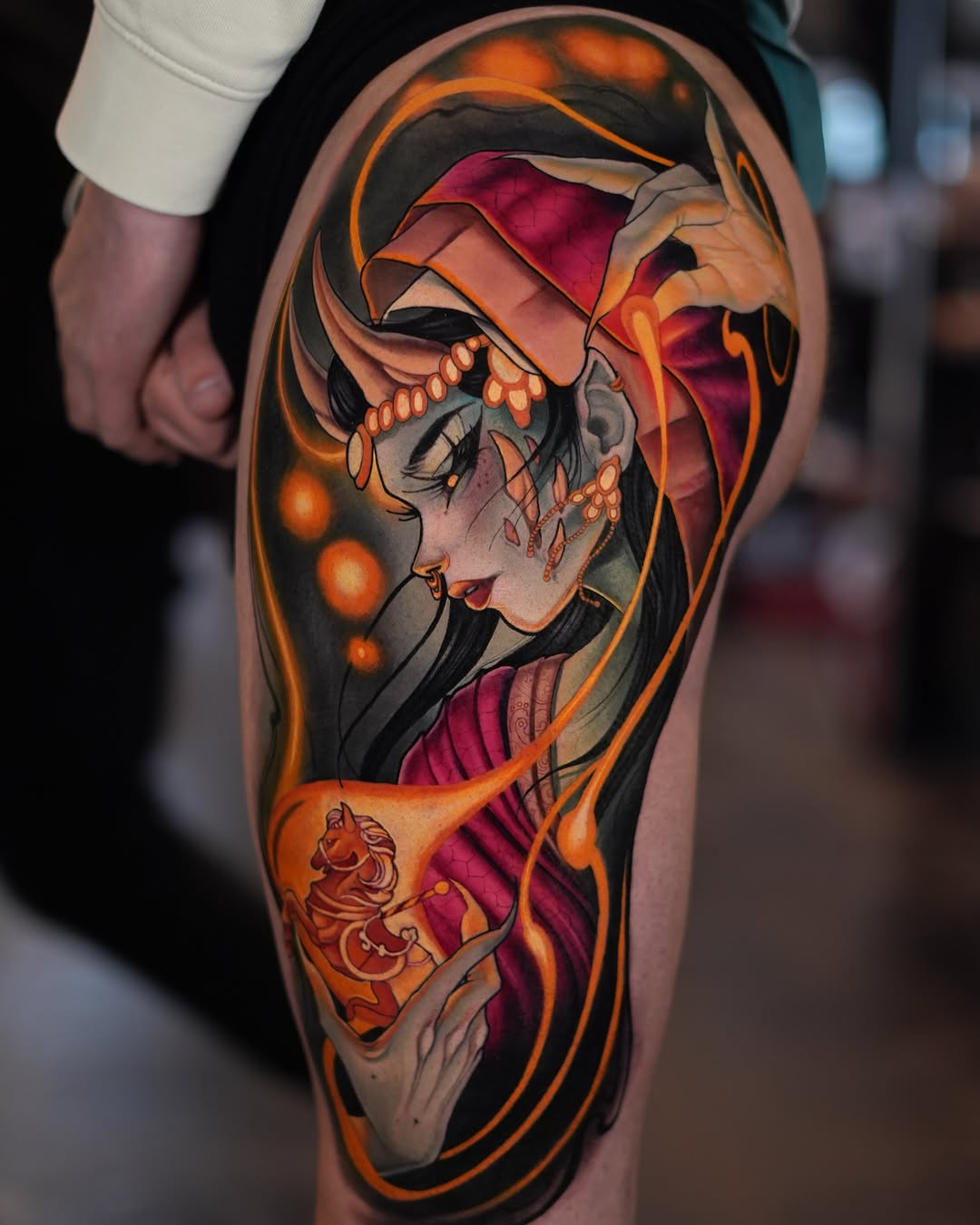 Colorful leg tattoo featuring a woman's face with skull makeup, wearing a red cap, surrounded by orange flames and decorative elements.