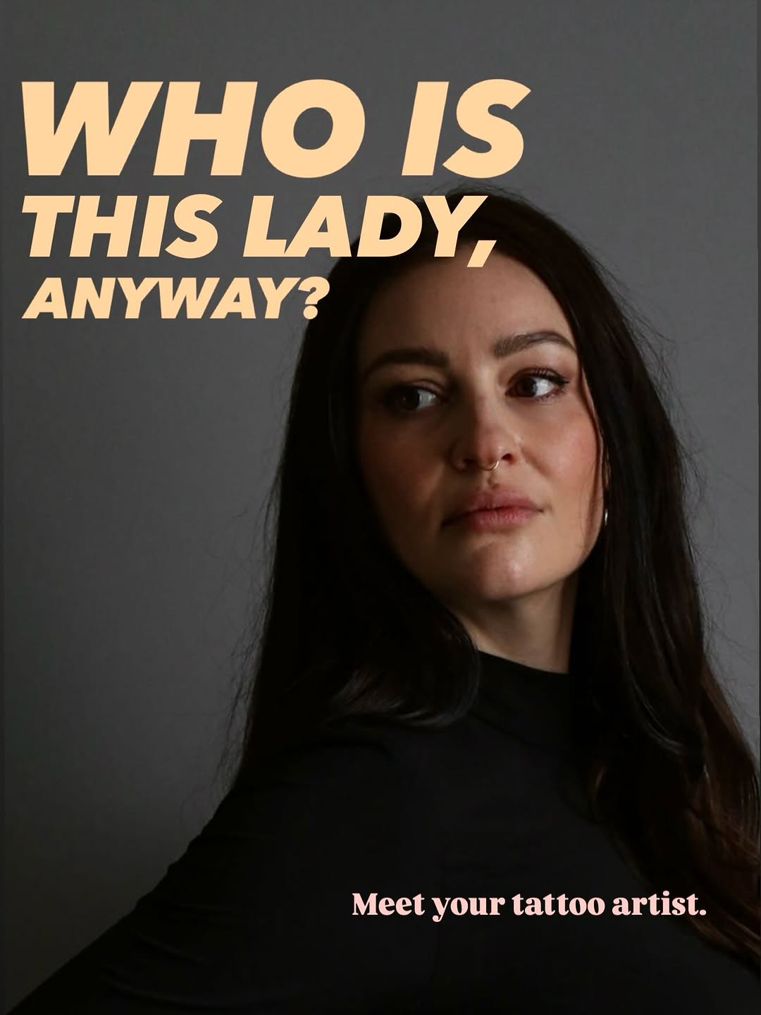 Portrait of a woman with long dark hair wearing black, looking upward and to the side against a gray background.
