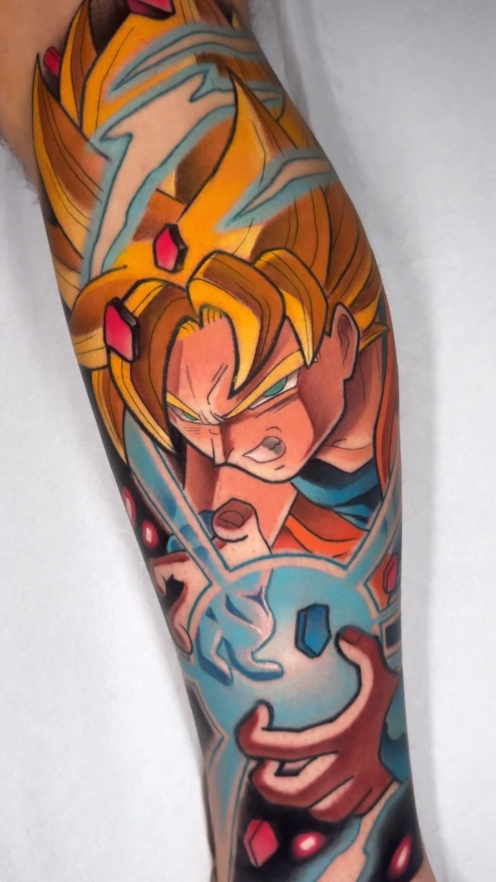 Colorful sleeve tattoo featuring an animated female character with orange hair and pink accents, surrounded by blue geometric patterns and red details on the forearm and upper arm.