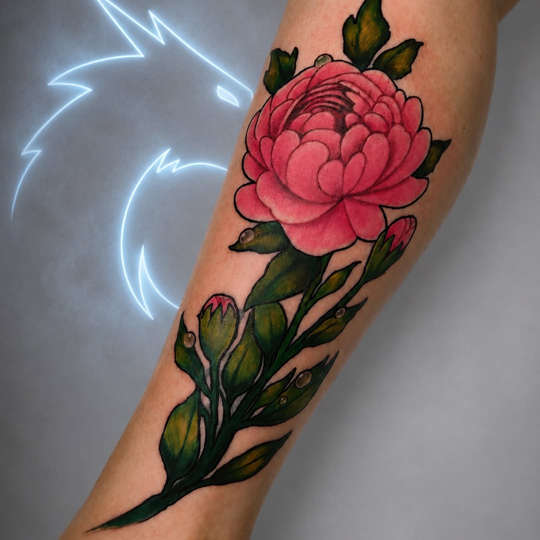 Pink peony flower with green leaves and unopened buds tattooed on an arm, featuring detailed shading and black outlines.