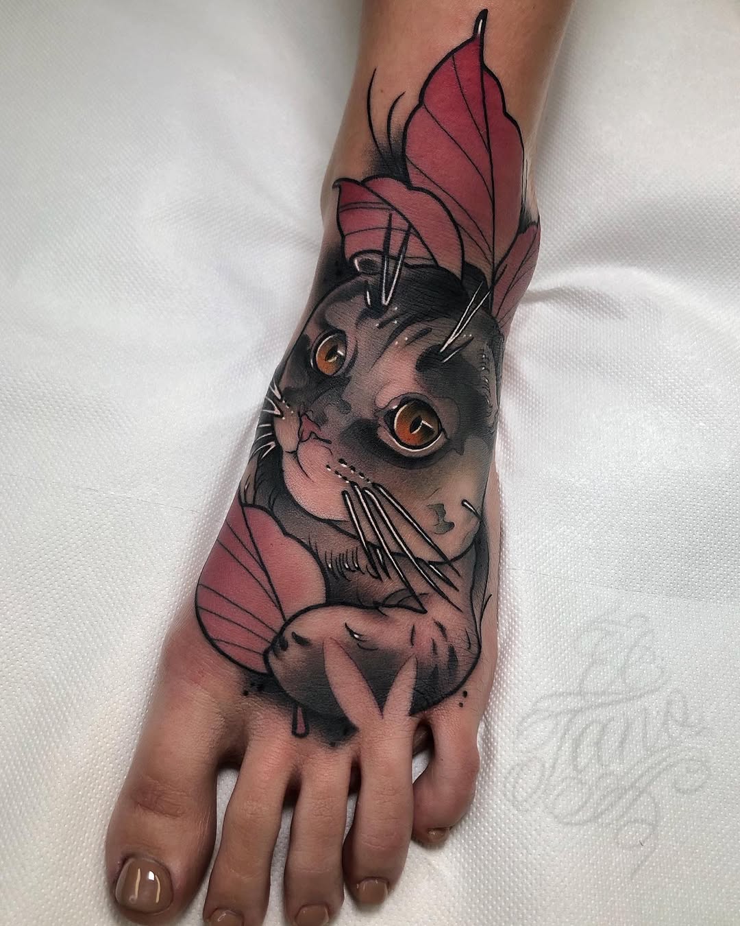 Black cat with amber eyes and pink butterfly wings tattooed on the back of a hand and foot.