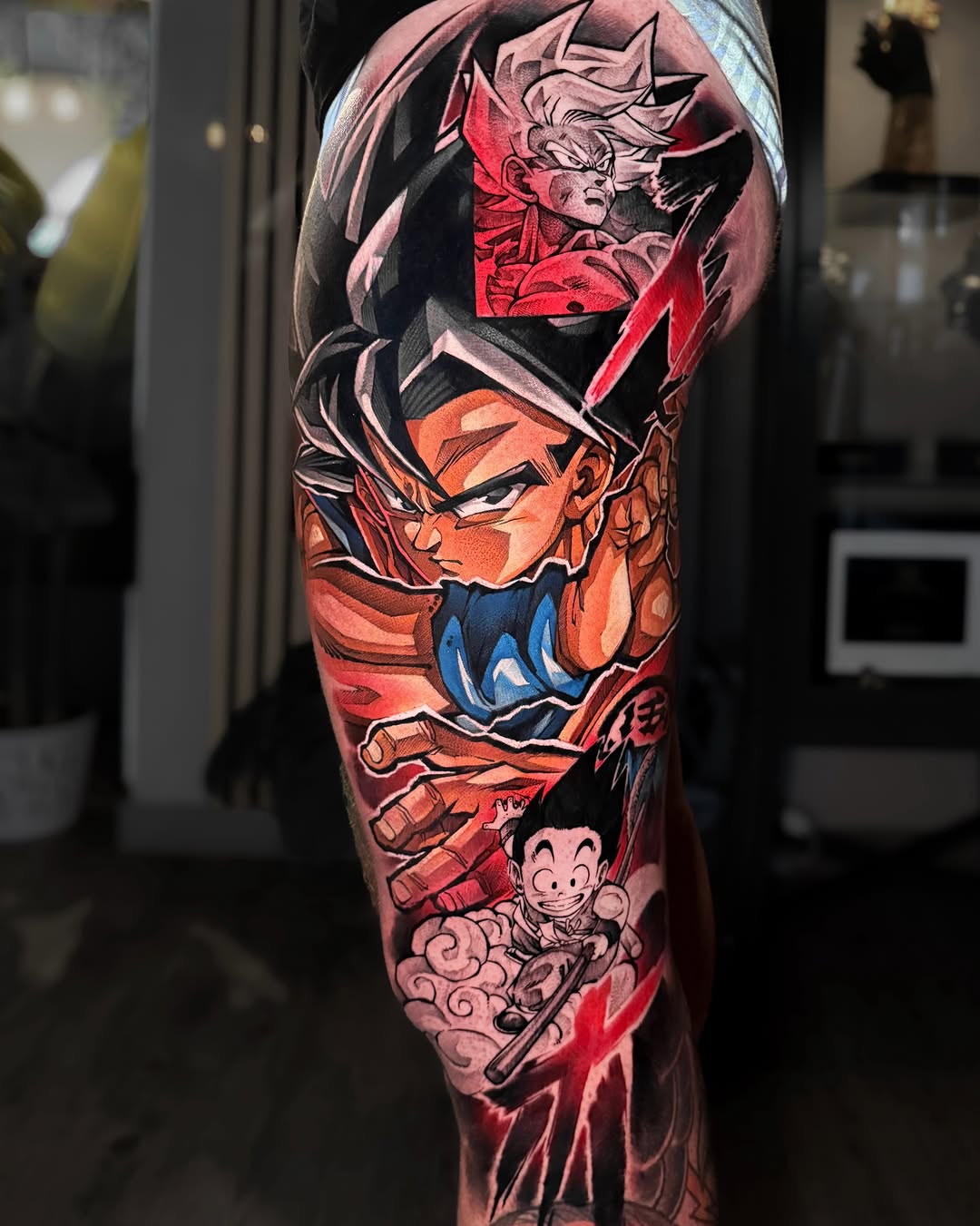 Colorful leg sleeve tattoo featuring multiple anime characters with red, orange, and blue tones, displayed on a thigh and calf.