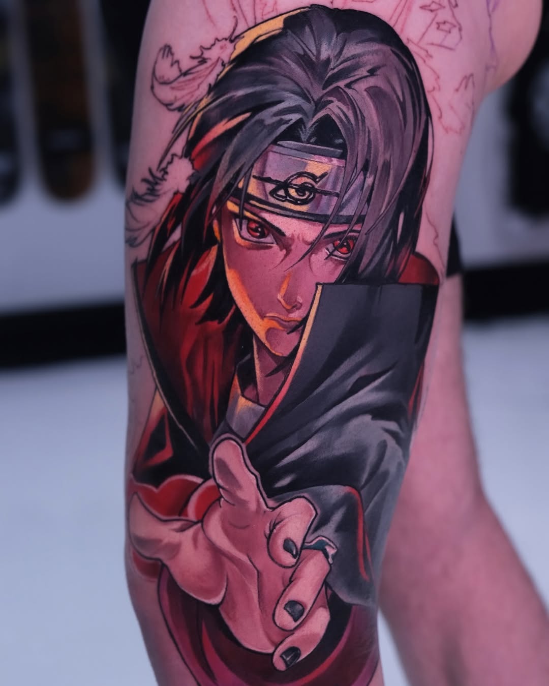 Colored shoulder tattoo featuring an anime character with dark hair and glasses, wearing a red and black outfit with outstretched hand.