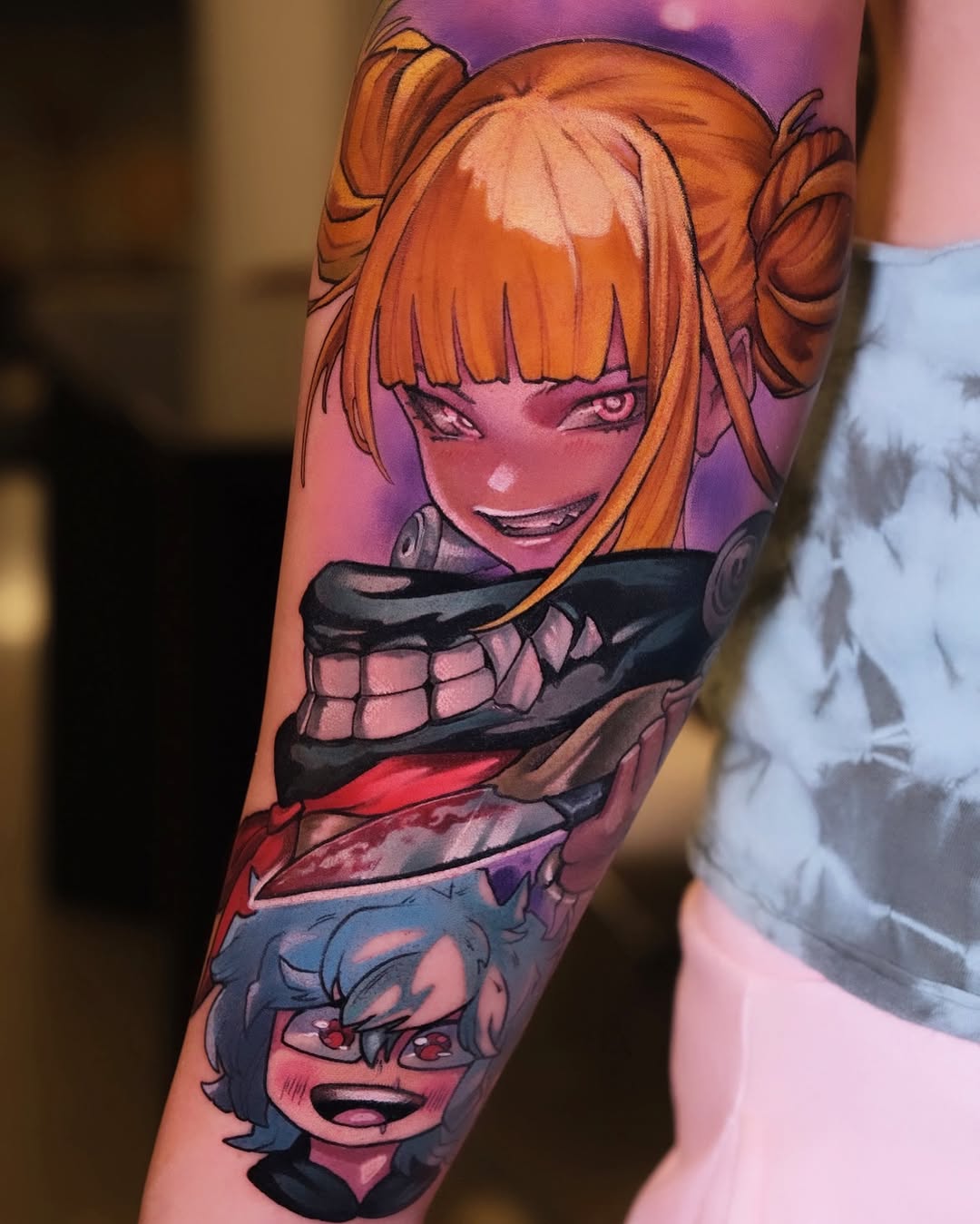 Colorful arm tattoo featuring two anime characters with orange and blue hair against a purple gradient background, displayed on the wearer's forearm.