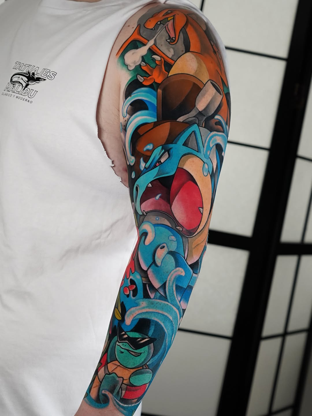 Colorful full-length arm sleeve tattoo featuring animated characters with vibrant orange, blue, red, and green hues on the wearer's shoulder to wrist.