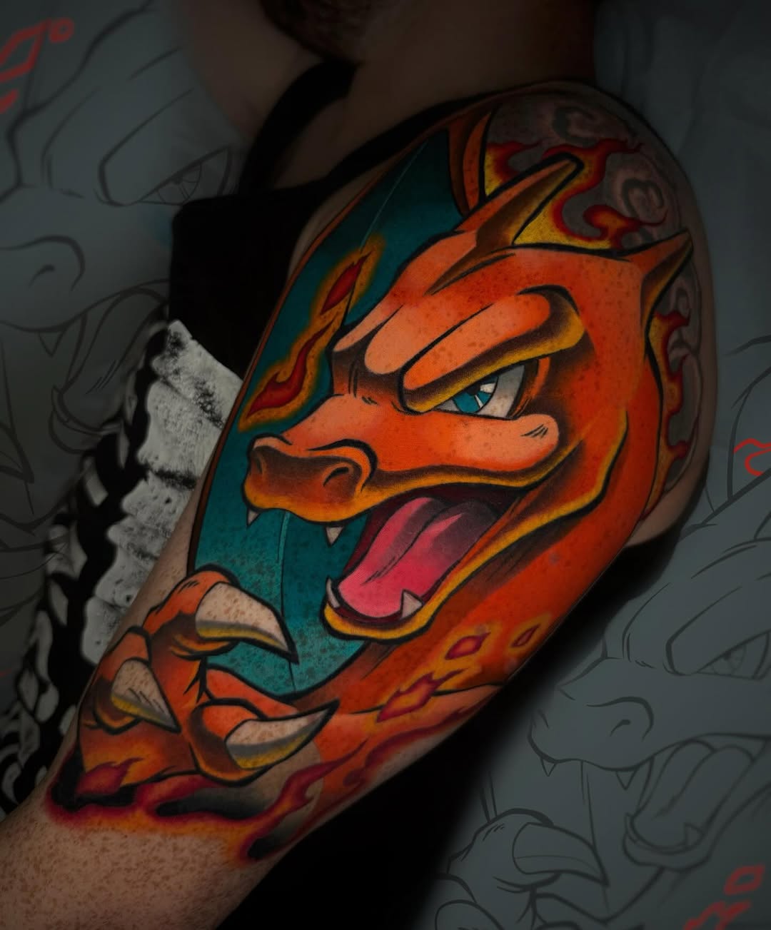 Colorful dragon tattoo on upper arm featuring orange and red scales, yellow accents, and teal background with open mouth and fierce expression.
