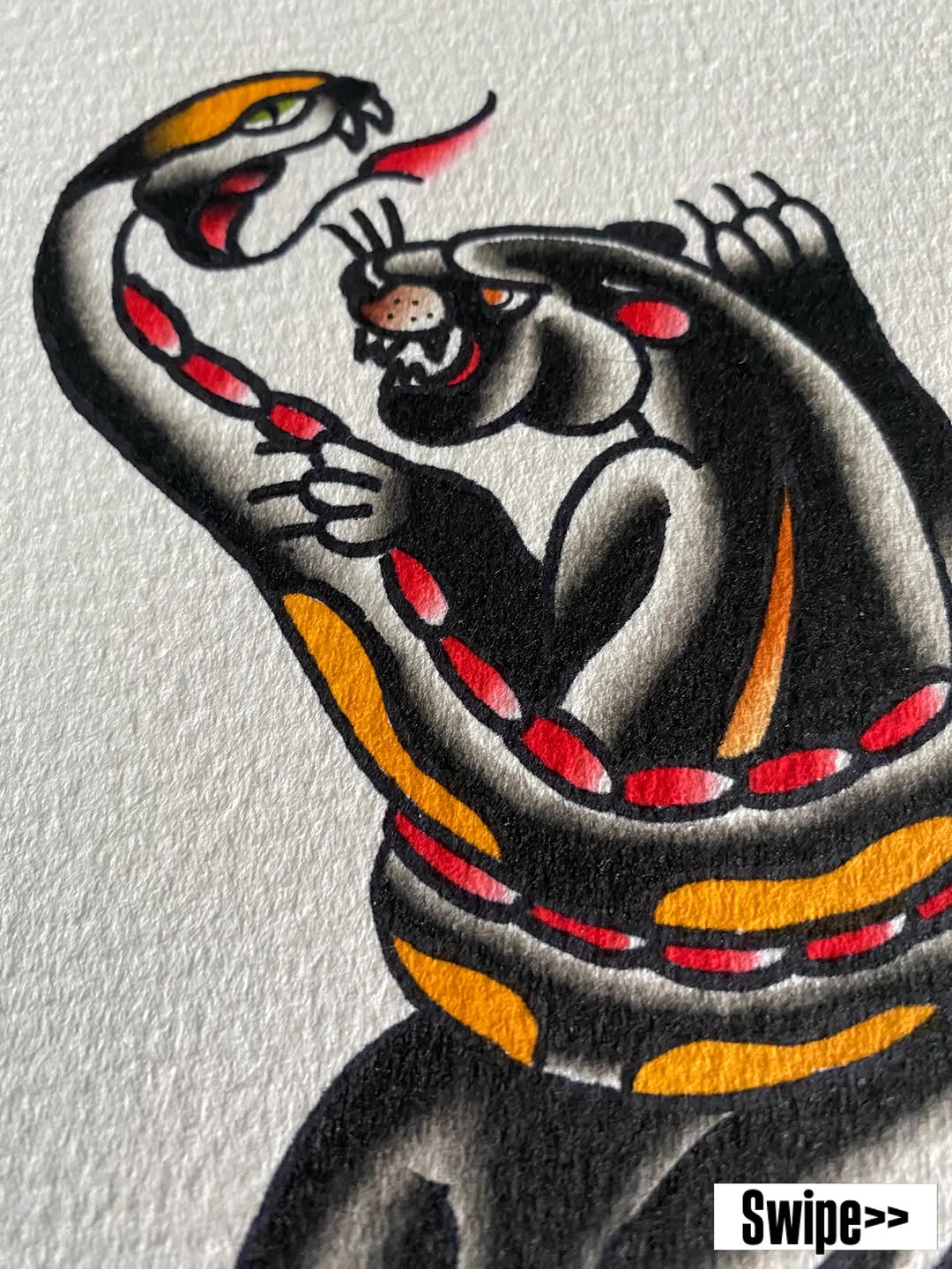 Colorful tattoo design featuring a coiled serpent with red and orange markings holding a smaller creature, displayed on an arm.