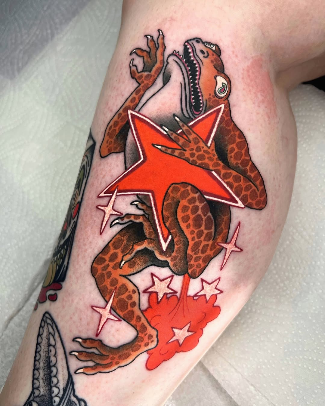 Red octopus with spotted orange-brown arms and decorative stars wrapped around a leg, featuring a large red star and smaller outlined stars.