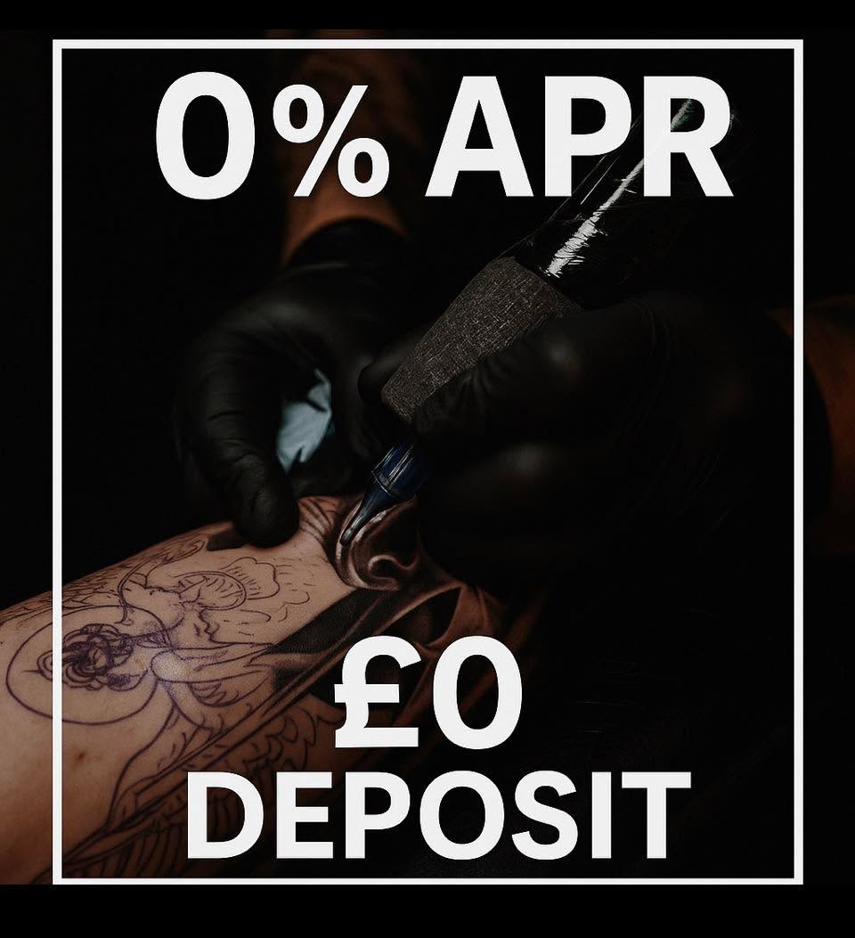 Tattoo artist applying decorative line work to a client's arm in black ink during a studio session.