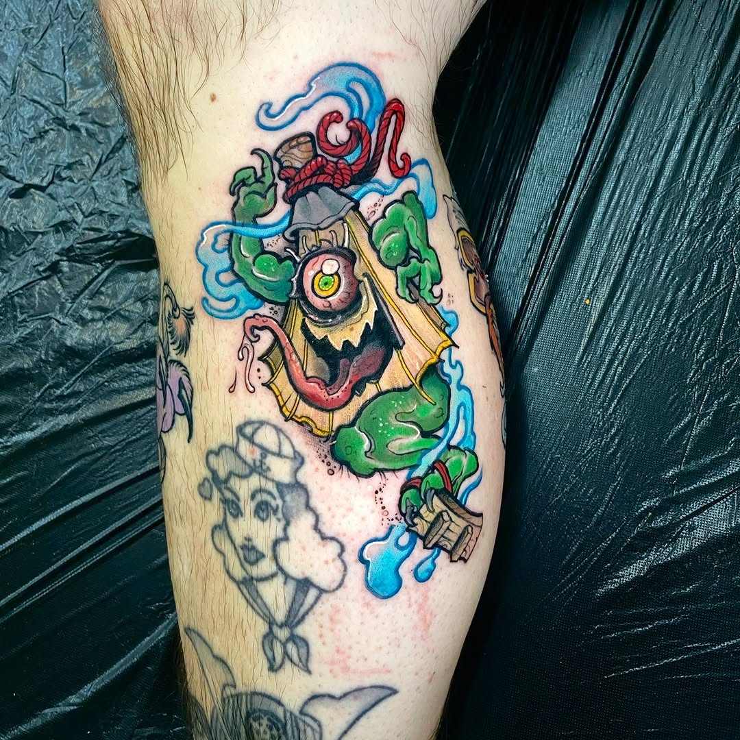 Colorful tattoo on a leg featuring a demon-like creature with red horns, green tentacles, yellow clothing, and blue water elements surrounding it.