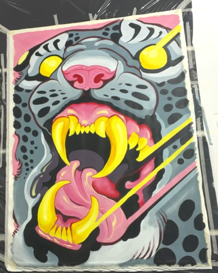 Colorful tattoo design featuring a snarling creature with yellow fangs, pink nose and mouth, gray spotted face, and yellow eyes on a pink background.