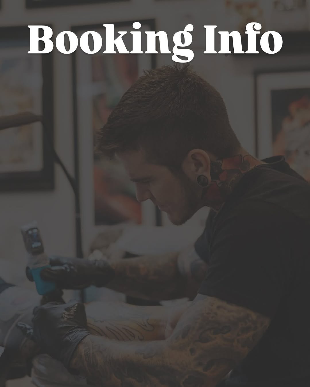 Tattoo artist with visible arm tattoos working on a client's leg during a booking consultation in a studio setting.