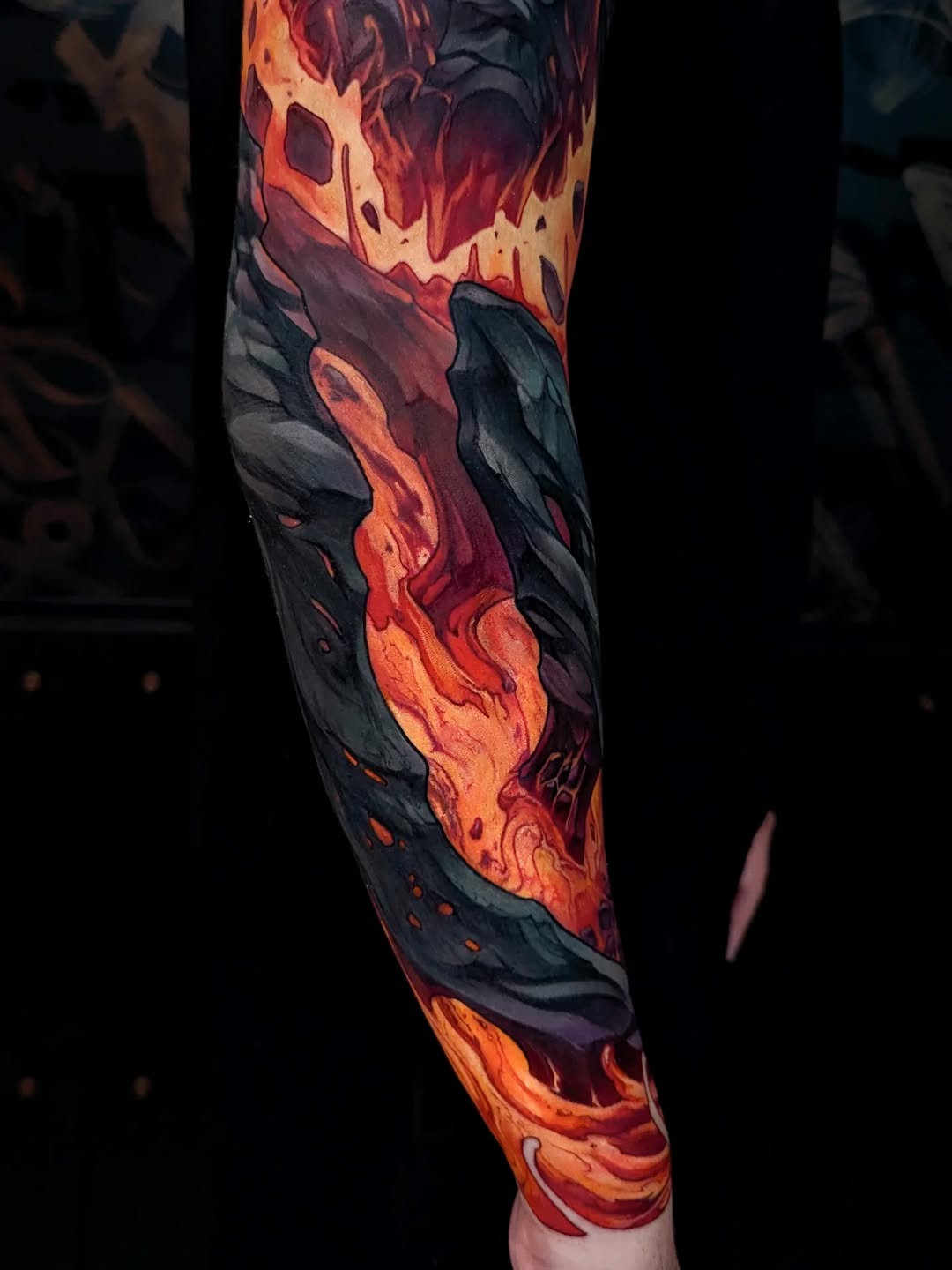 Full-length arm sleeve tattoo featuring flowing lava and molten rock in orange, red, and yellow against dark charcoal backgrounds.