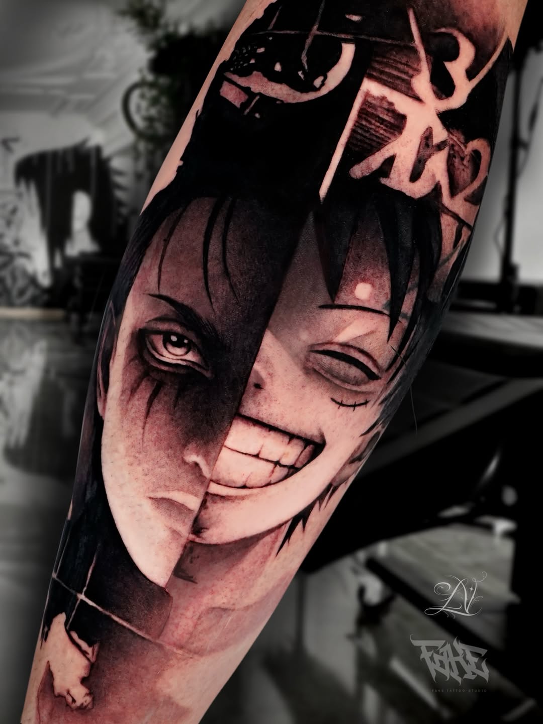 Split-face portrait tattoo on forearm featuring contrasting light and dark halves with detailed eyes and grinning expression in red and black ink.