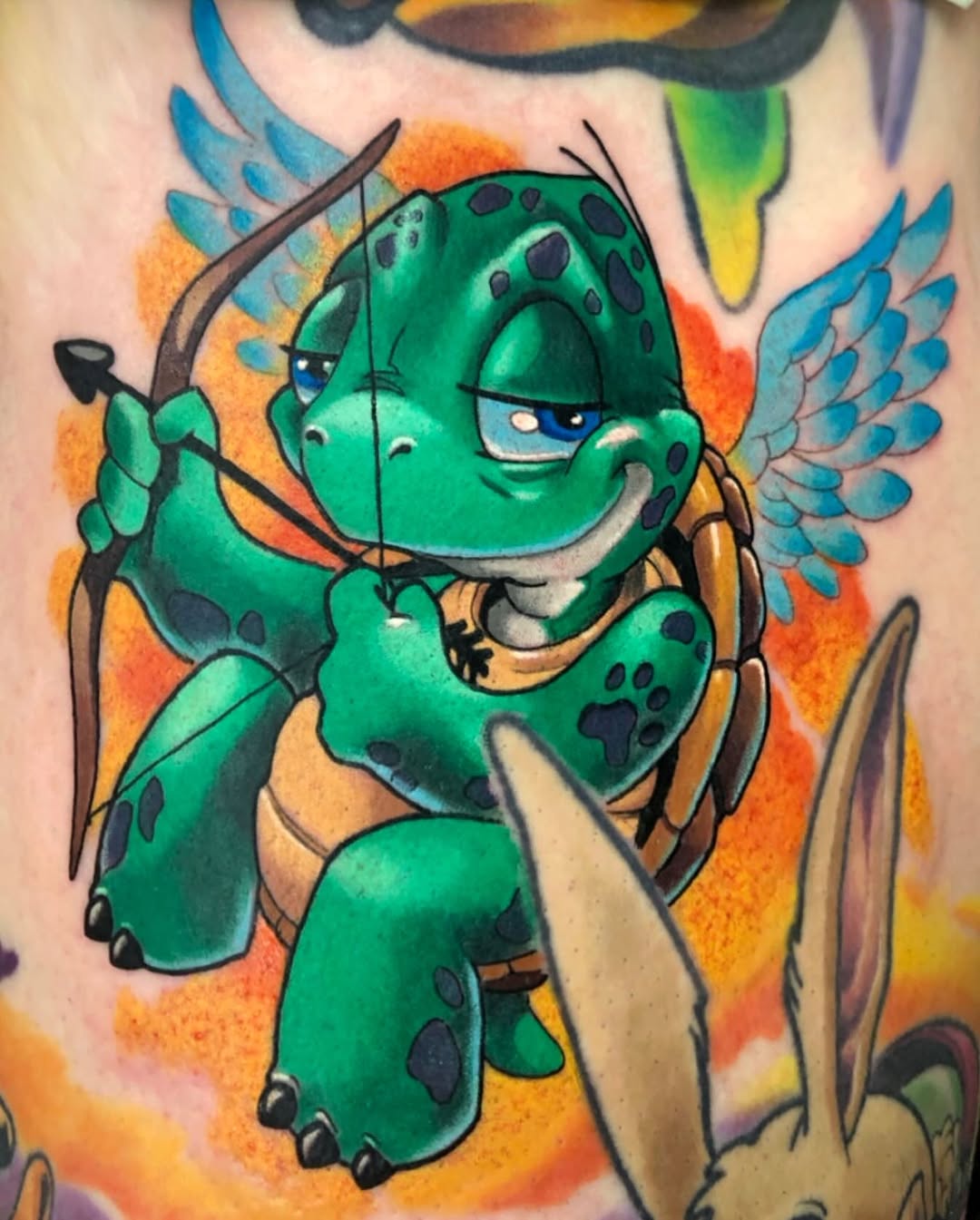Green winged dragon character with blue eyes and spotted pattern, holding a sword, surrounded by orange and blue gradient background on skin.