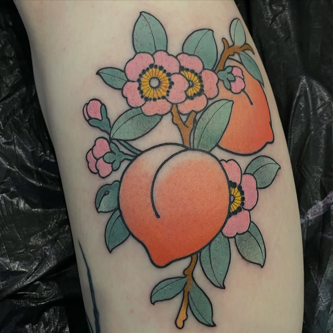 Colorful tattoo on leg featuring a large orange balloon surrounded by pink flowers with yellow centers and green leaves on a brown stem.