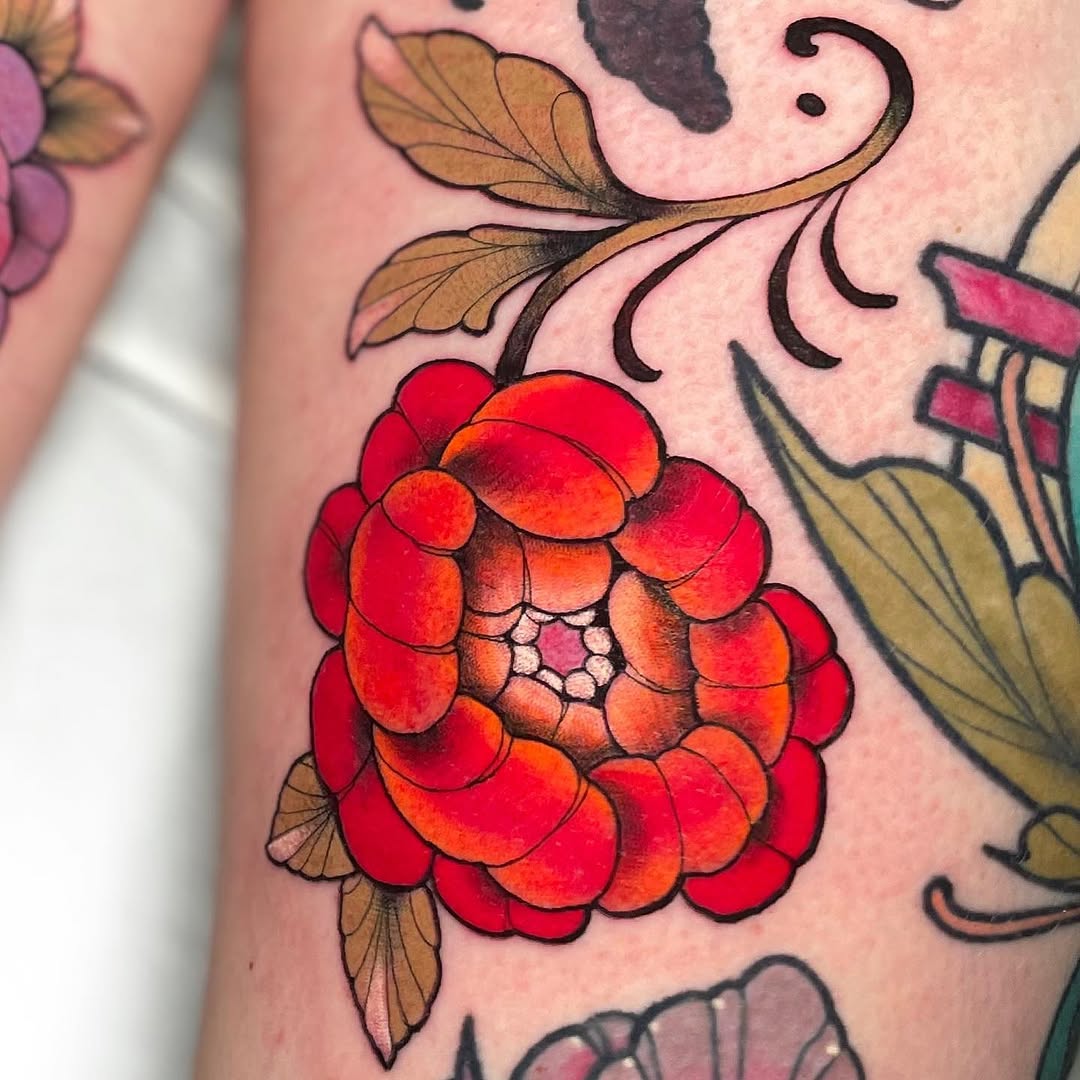 Vibrant red and orange raspberry with brown leafy stems and decorative black swirls tattooed on pale skin, part of a larger floral sleeve design.