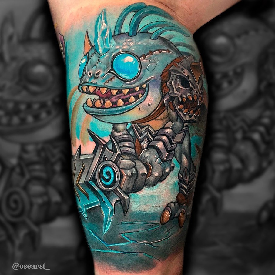 Colorful leg tattoo featuring a creature with a large eye, sharp teeth, mechanical armor, and spiky features in turquoise, brown, and orange tones.