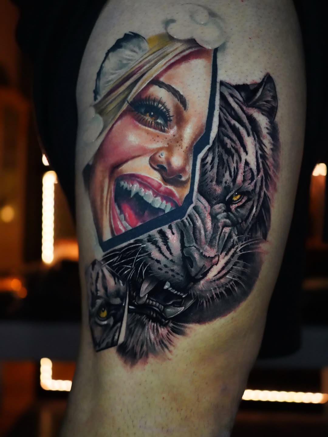 Colorful shoulder tattoo featuring a woman's face with a headwrap and an adjacent wolf head with golden eyes.