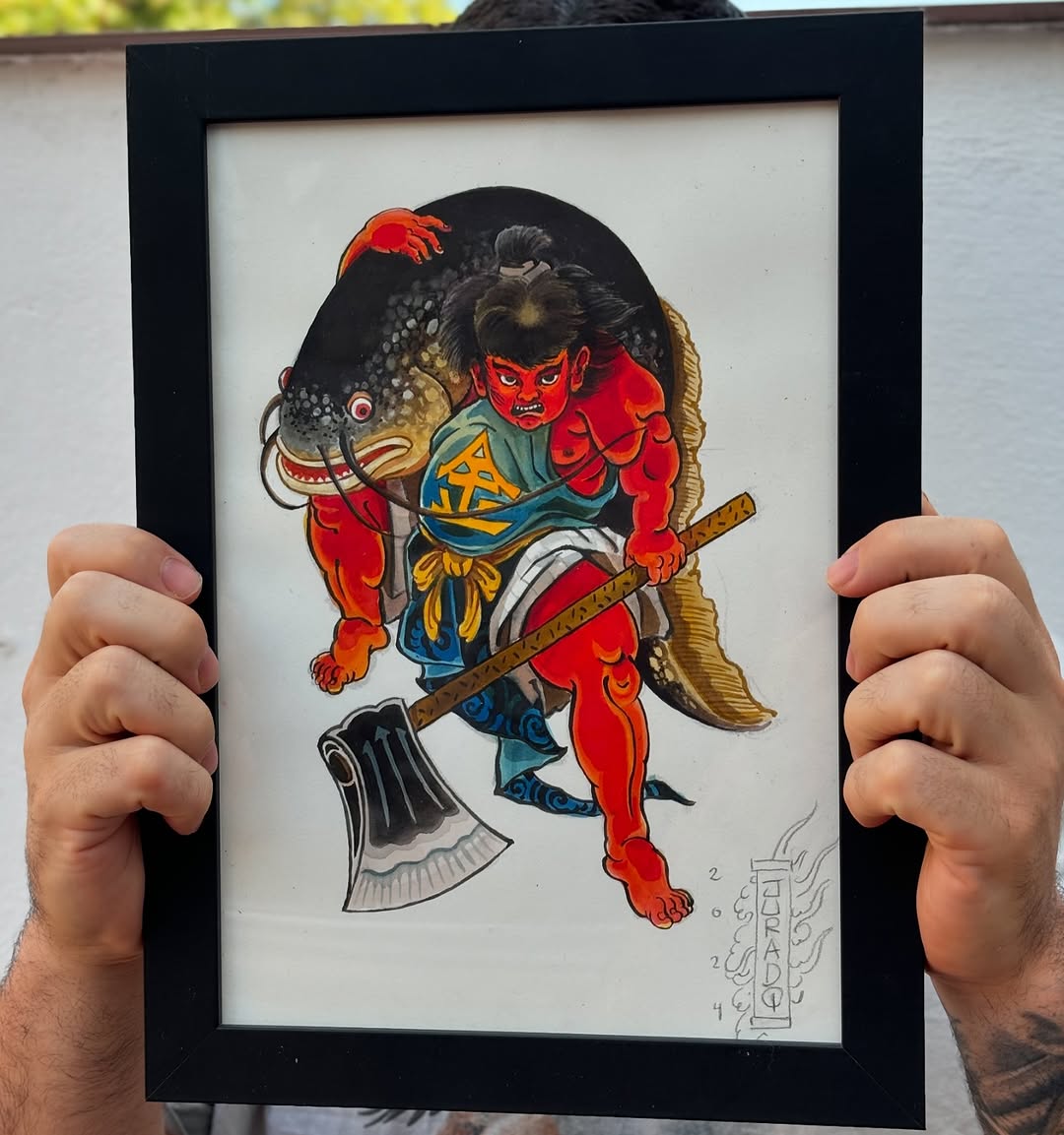 Framed artwork featuring a red demon figure with black hair holding an axe and fish, wearing blue clothing with gold accents, colored in red, blue, gold, and black.
