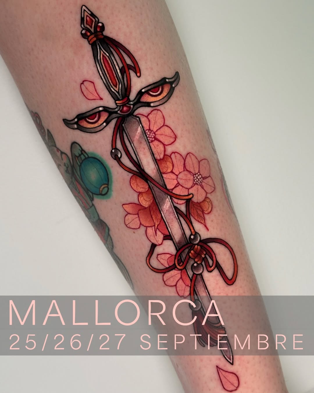 Decorative cross with sword and red flowers surrounded by pink petals and a teal orb, tattooed on the inner forearm.