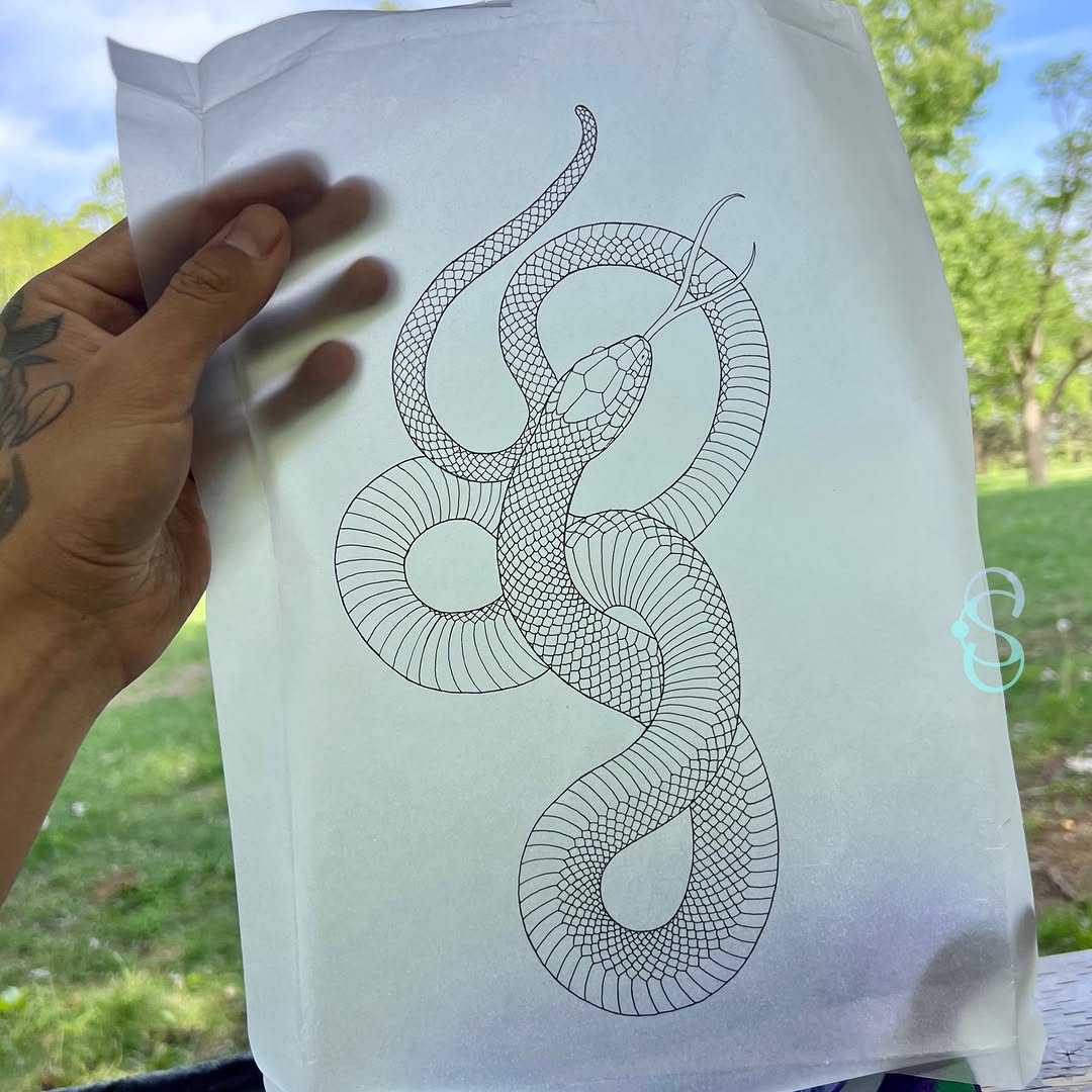Intricate line drawing of an intertwined snake with scaled texture and forked tongue, displayed on white paper outdoors.