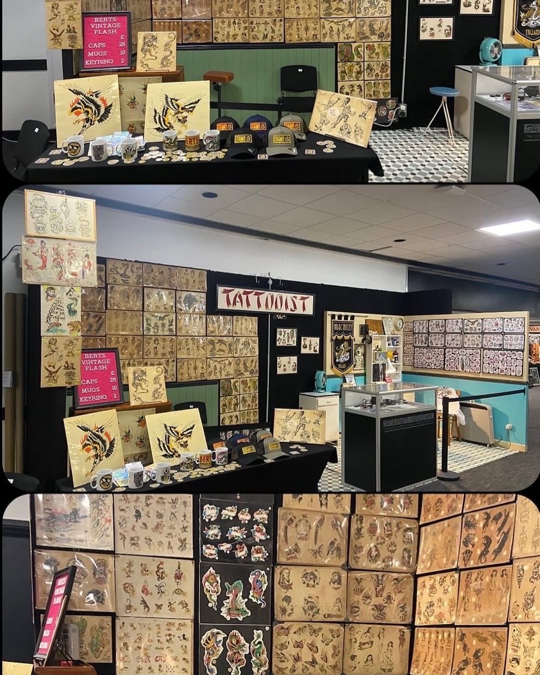 Tattoo artist shop display featuring flash art sheets with birds, dragons, and ornamental designs in black ink and color on cream paper, with merchandise and portfolio samples.
