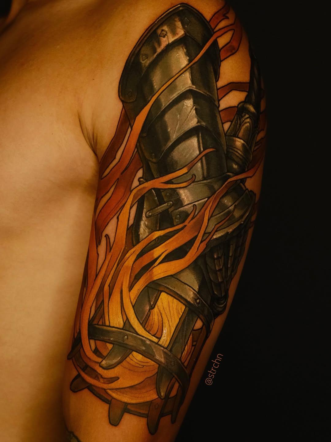 Biomechanical armor leg tattoo featuring metallic plating and orange flame-like wrapping elements on the upper thigh and calf area.