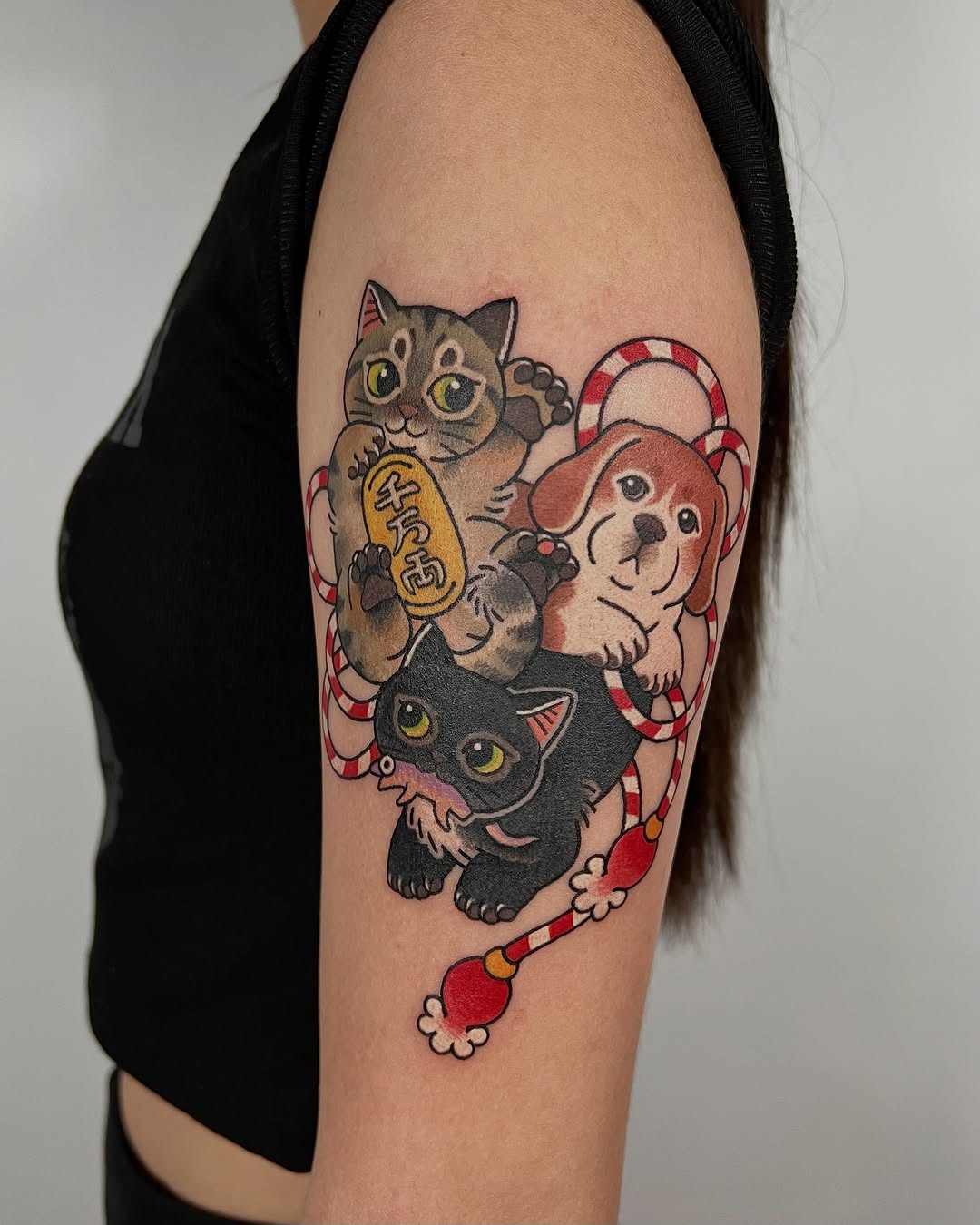 Three cats and a dog stacked vertically with red and white candy cane decorations on the upper arm, featuring gold, brown, black, and red colors.