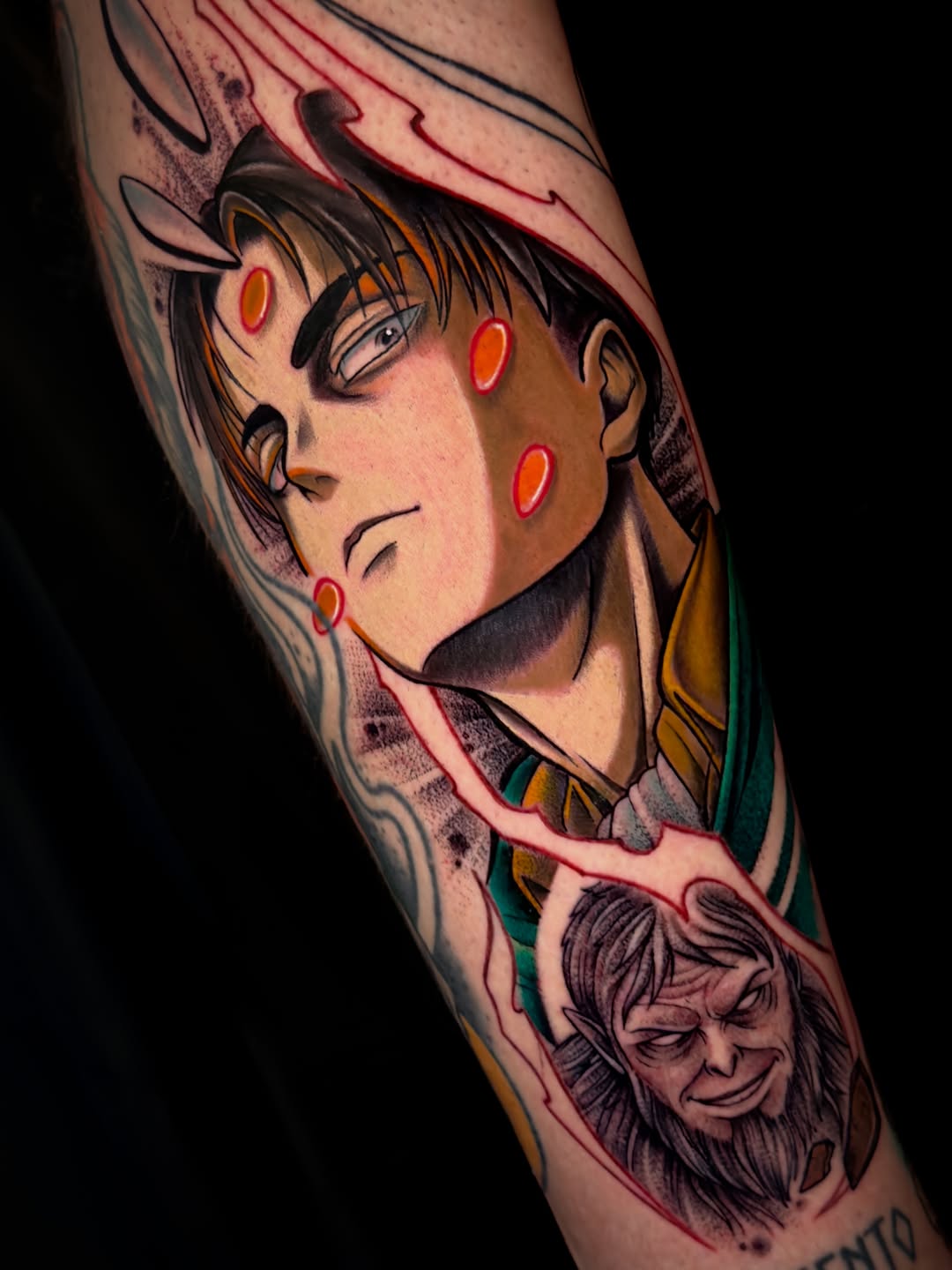 Colorful tattoo on an arm featuring an anime character with red markings and a smaller face below, rendered in vibrant colors and shading.