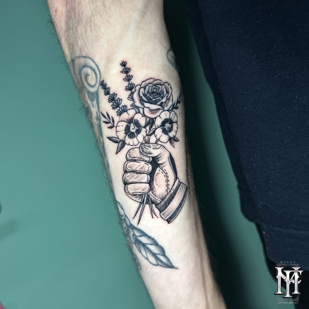 A hand holding a bouquet of roses, pansies, and lavender sprigs on a person's forearm, rendered in black ink on pale skin.