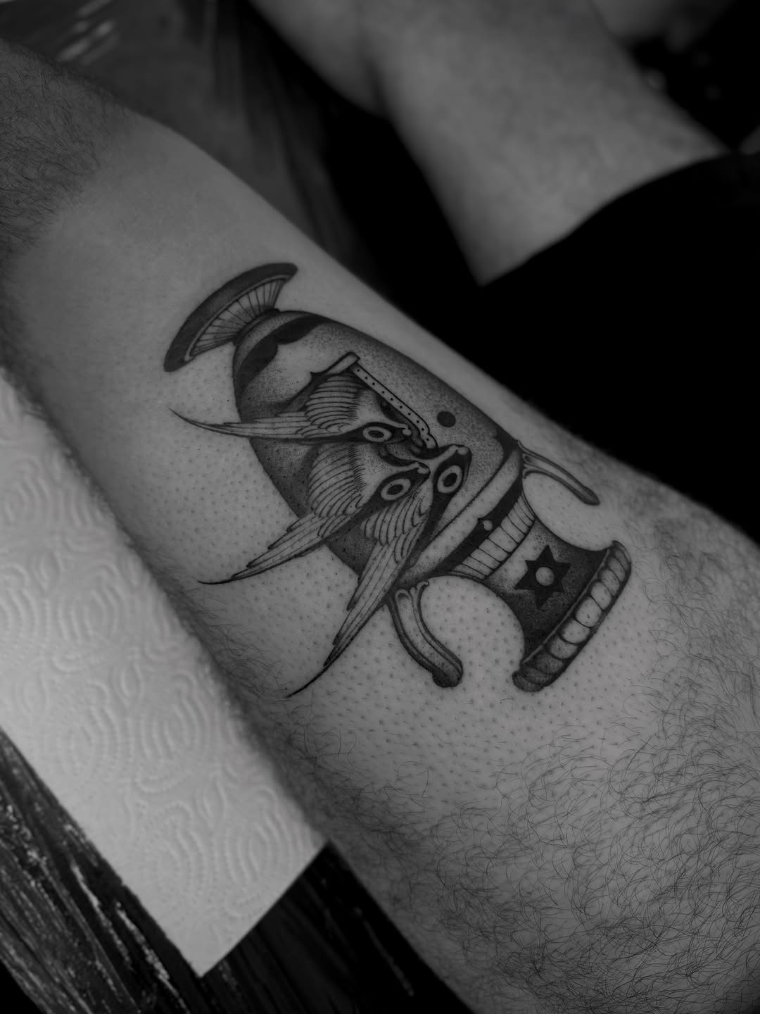 Detailed black ink tattoo of an ornate elephant with decorative saddle and tusks on the forearm.