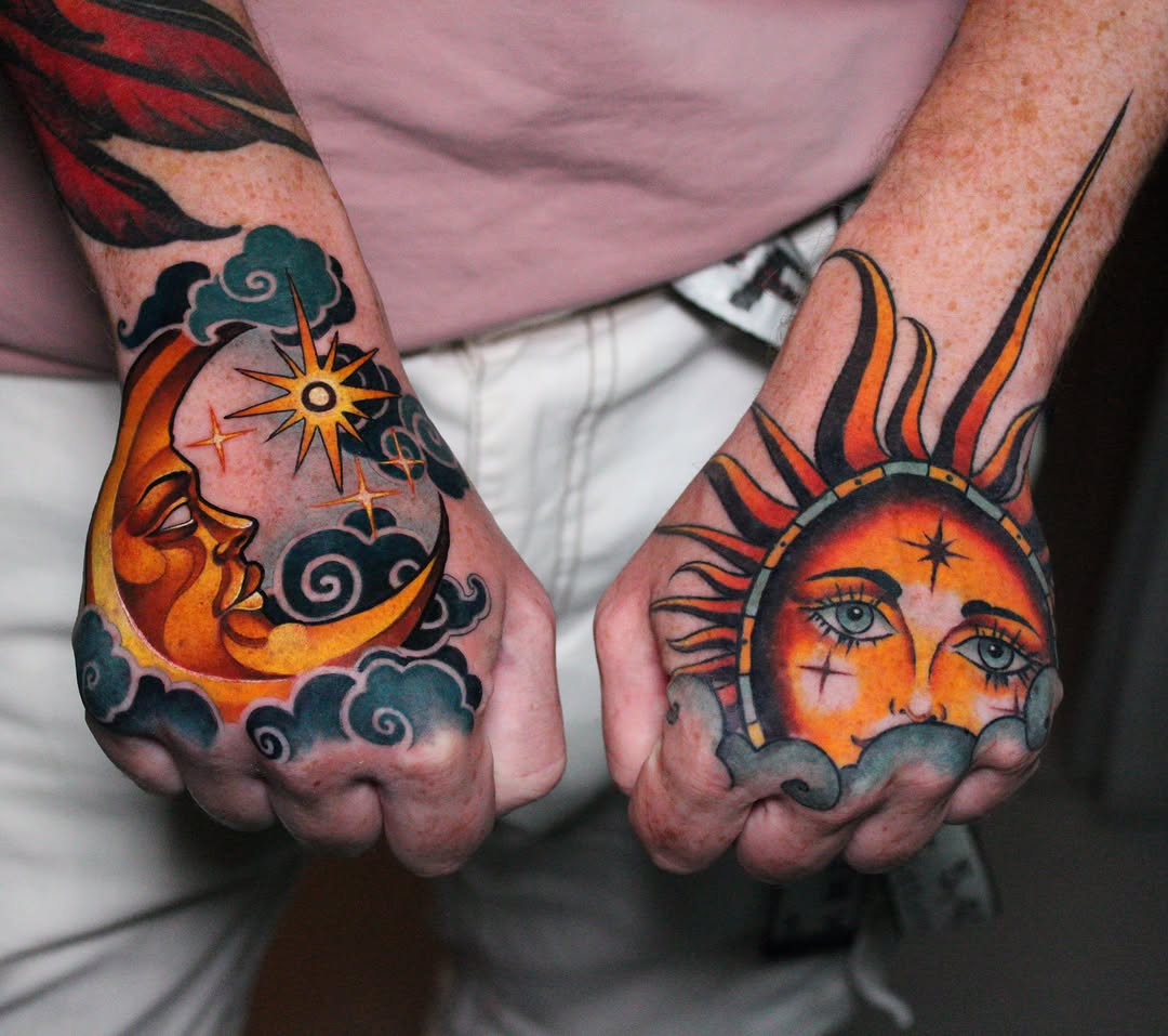 Matching hand tattoos featuring a crescent moon and sun with faces, clouds, and stars in orange, yellow, black, and teal colors.
